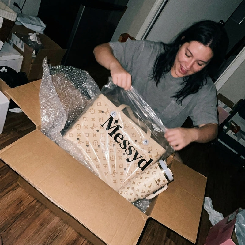 Cream Messyd tote and matching tumbler held after unboxing