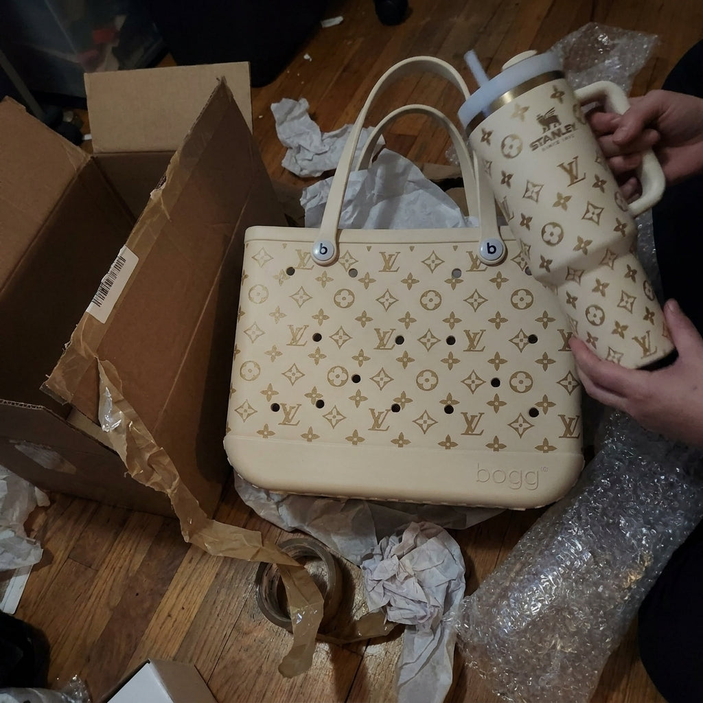 Hands holding a cream tumbler with the matching tote on the floor