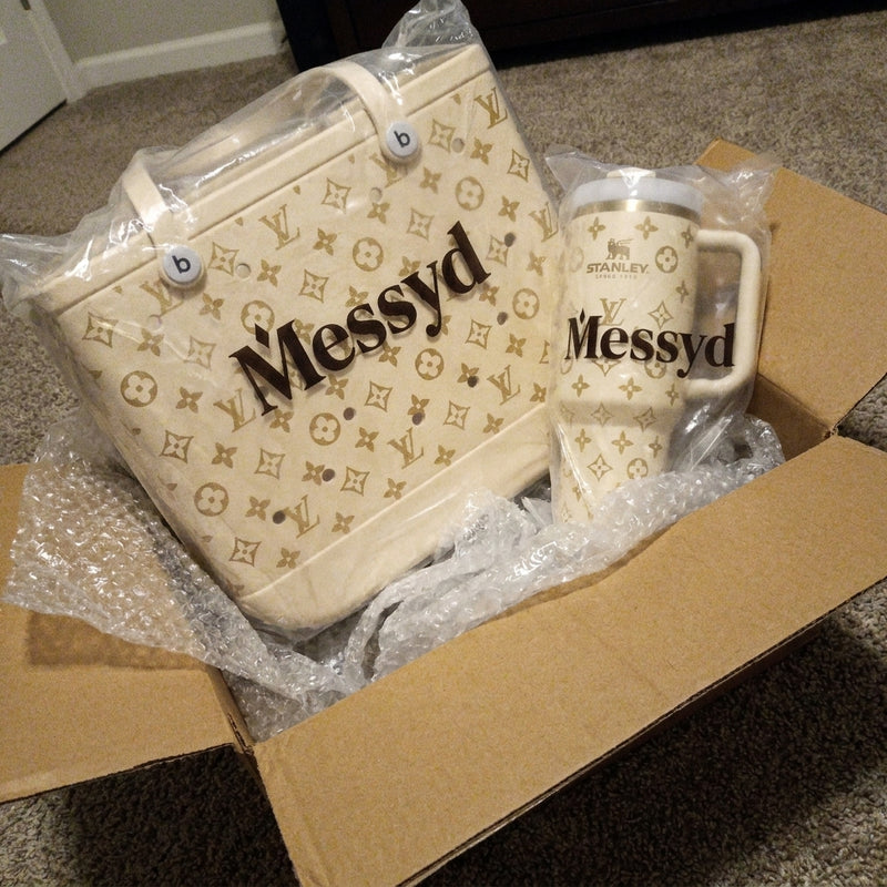 Cream Messyd tote and tumbler in plastic inside a shipping box