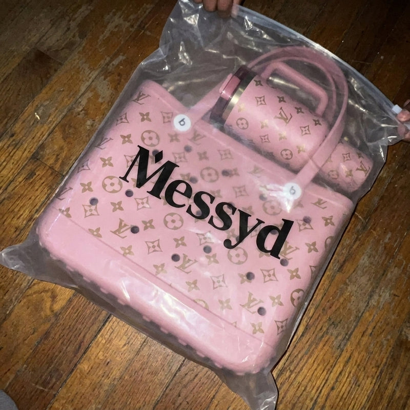 Pink Messyd tote and tumbler still in the branded plastic bag