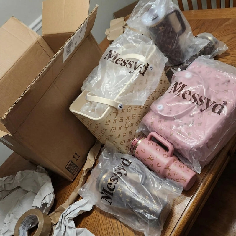 Cream, pink, and brown Messyd bags and tumblers on a table